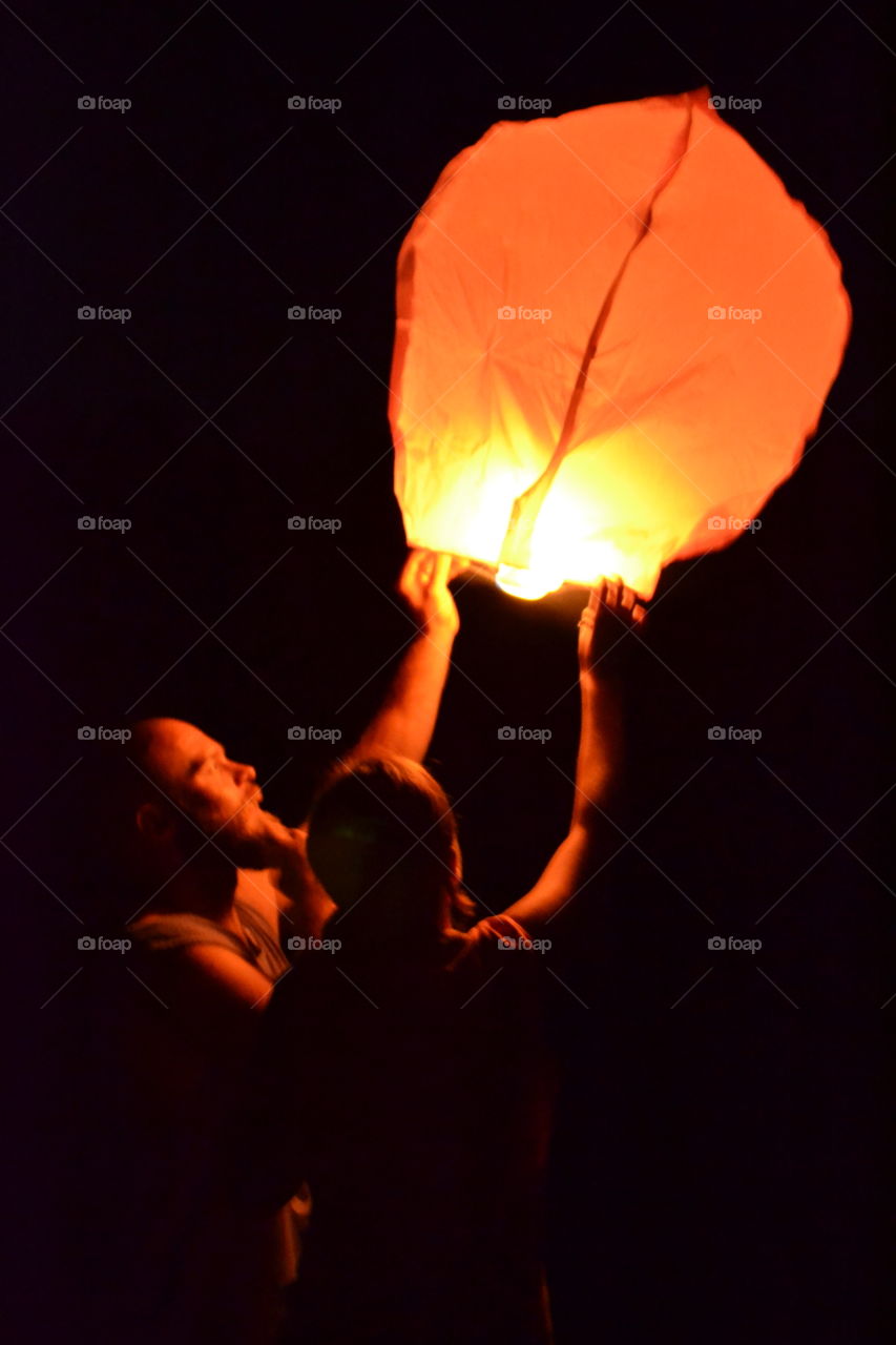 Two people holding lantern at night