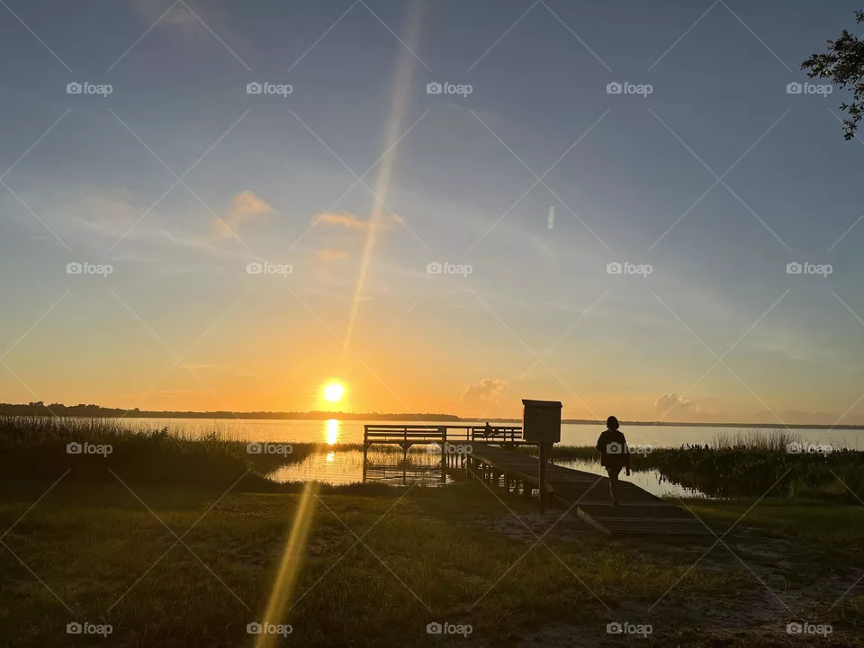 Sunrise by a pier and a big lake.