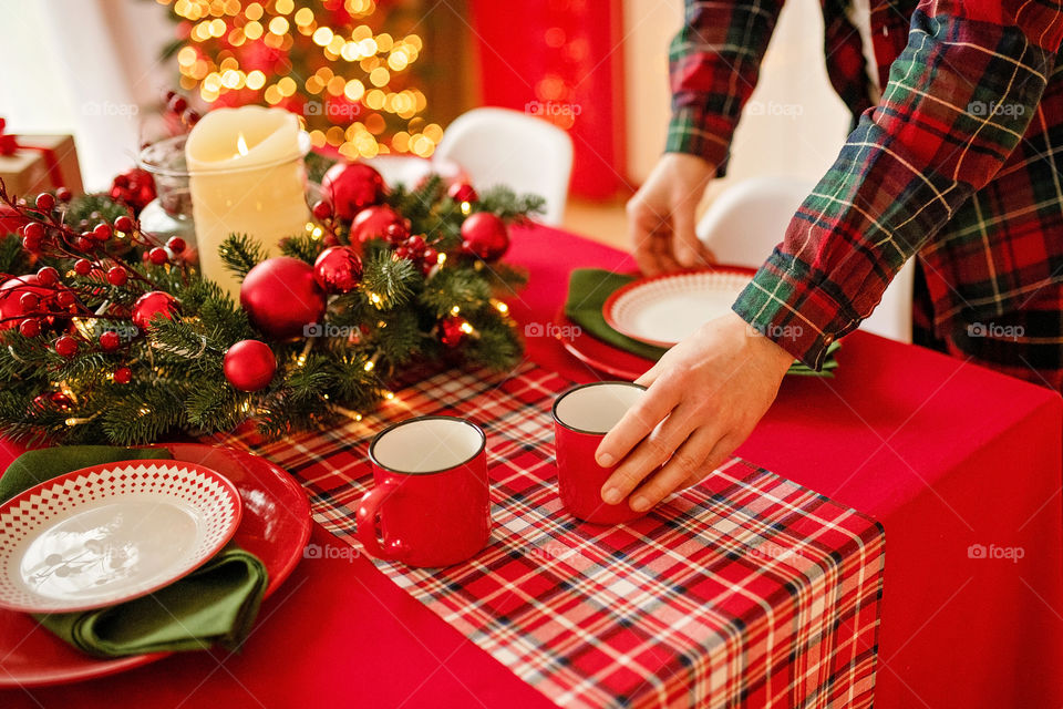 man sets a beautiful decorated winter table for a festive dinner.  Merry Christmas and Happy New Year.