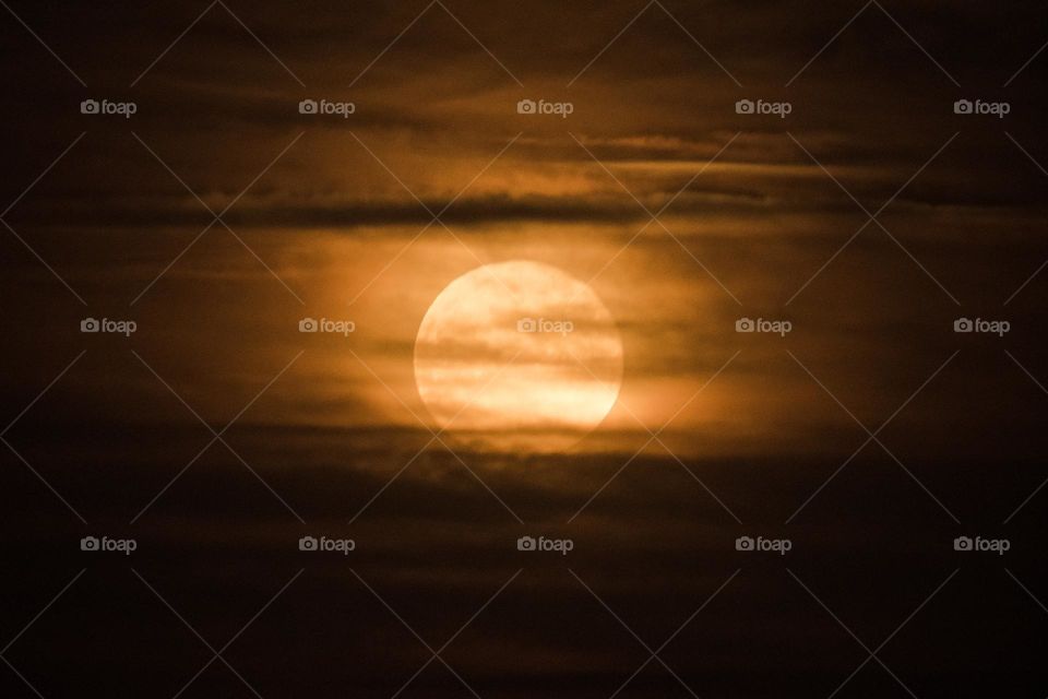 Rising moon seen through the clouds