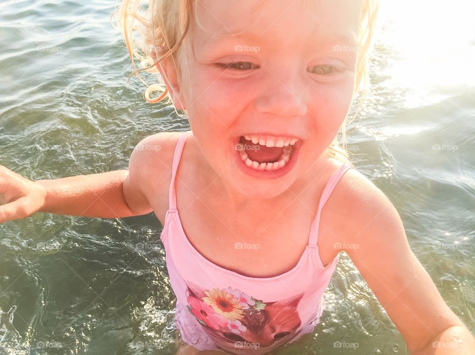 Young girl playing in the ocean at Ribban beach in Malmö Sweden.