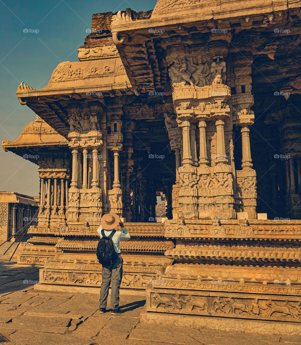 A tourist taking a photograph of the architecture of Vittala temple complex - India - Hampi 