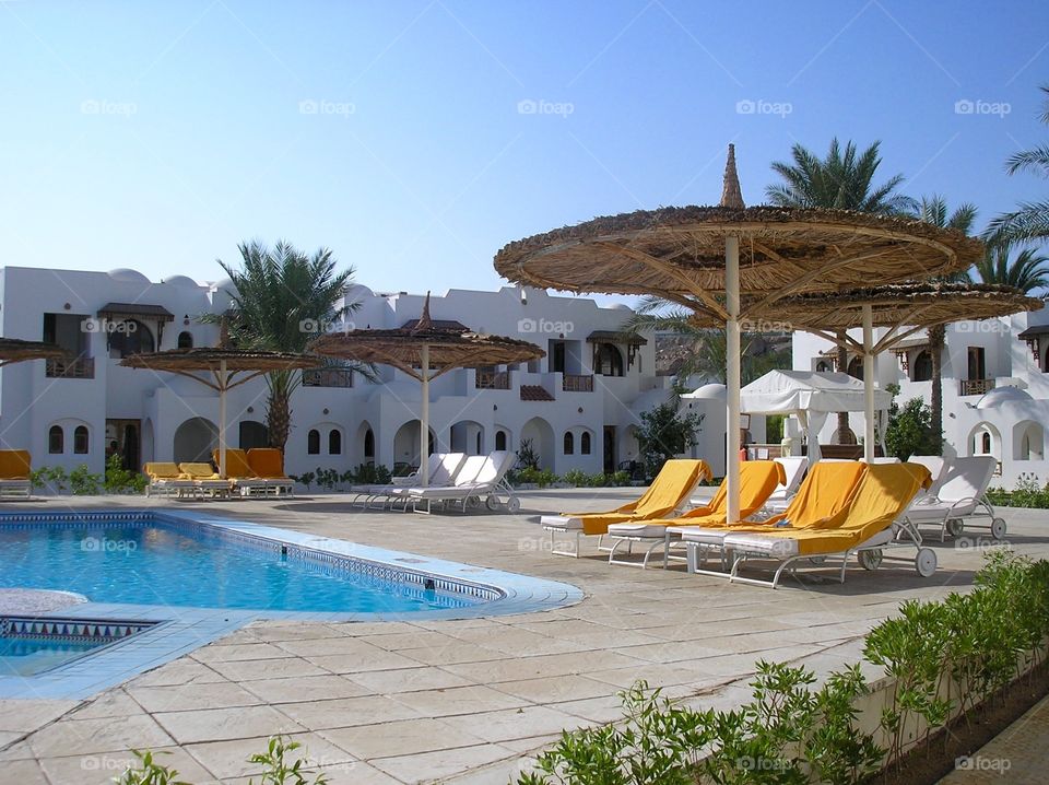 Territory of hotel in Egypt with a pool, parasols and sun loungers