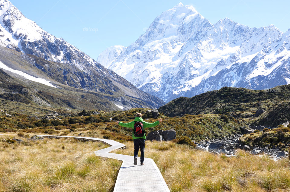 Man enjoying the views on his beautiful hike in the snowy mountains of New Zealand