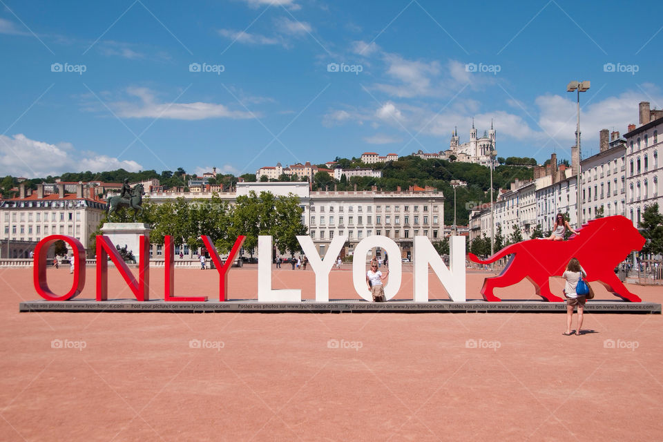 Woman sits in the O in the only Lyon sculpture in Lyon France