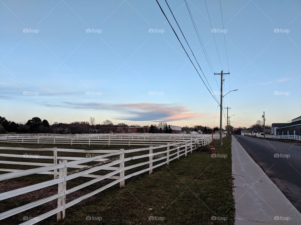 road, sidewalk, and wooden fences, early evening