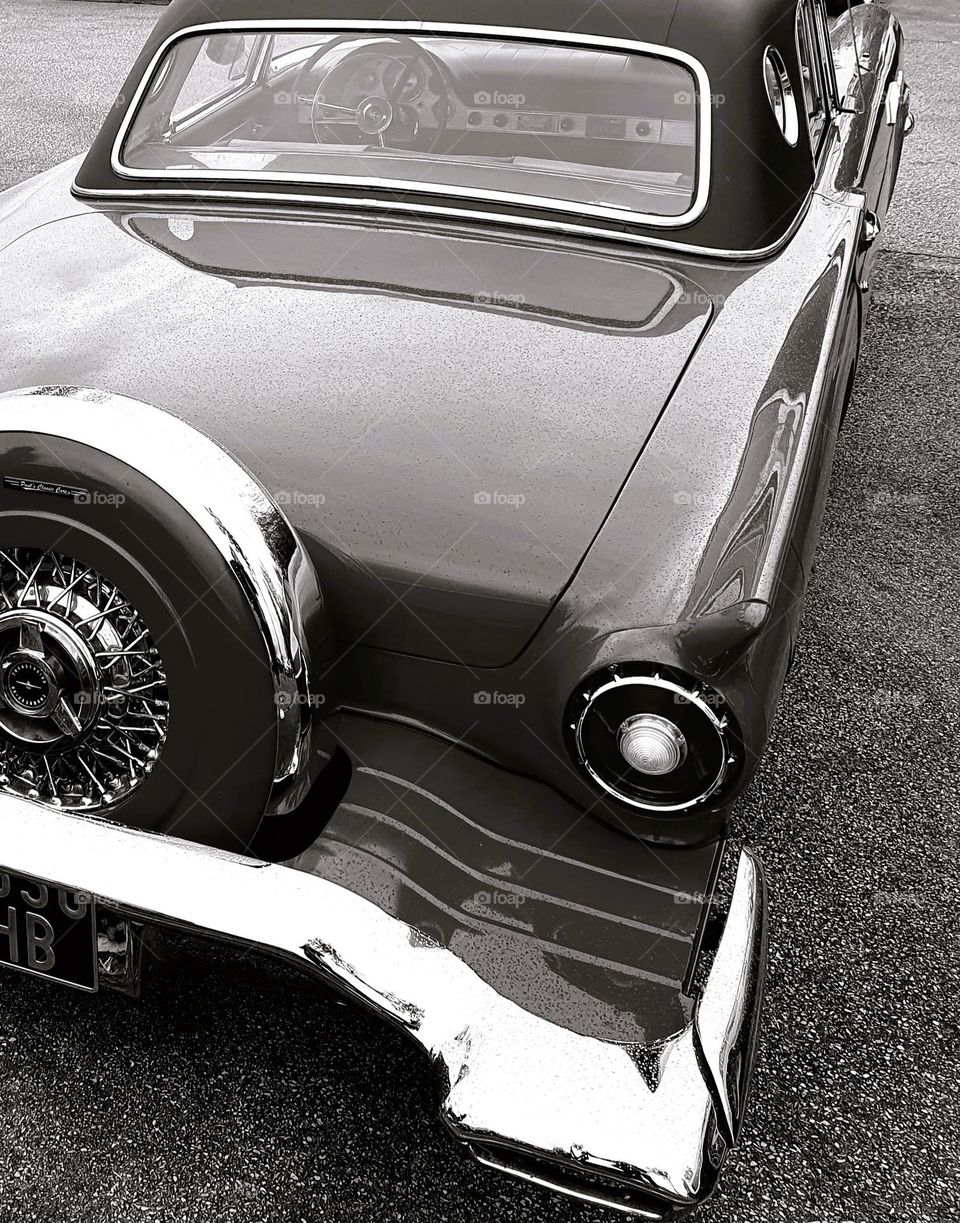 Sepia shot of the back of a Ford Thunderbird showing the spare tyre, rear light and rear window at Cherbourg car show
