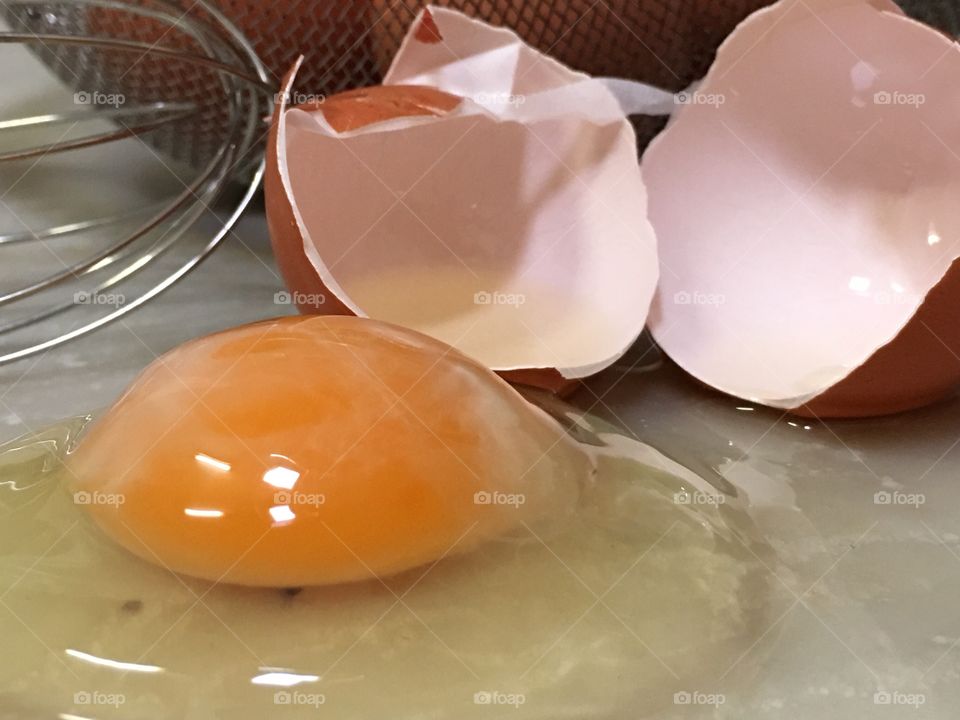 Raw cracked brown egg on countertop