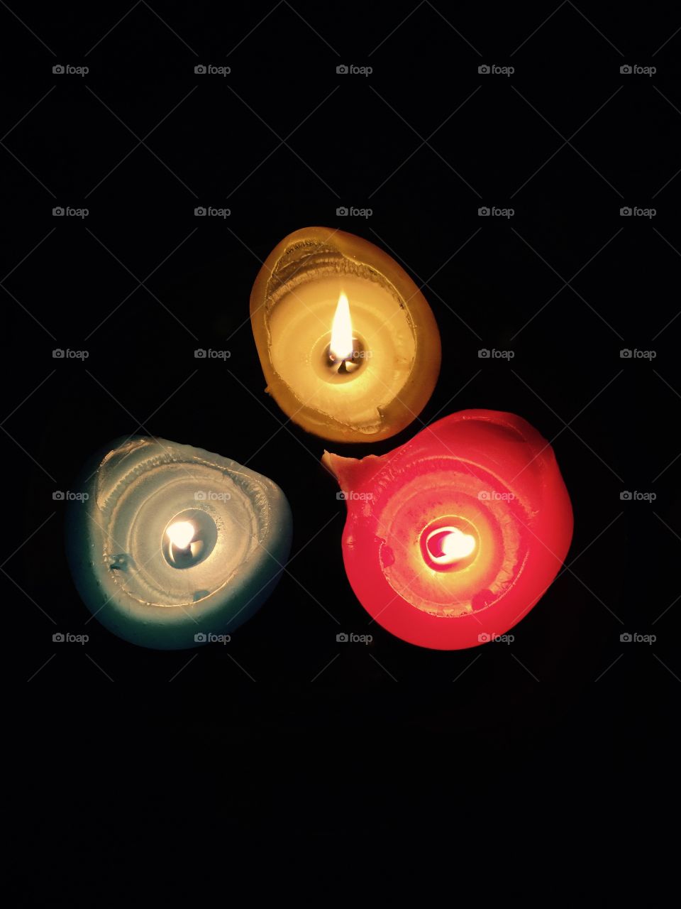Three colors. Thick colored lit candles, top view