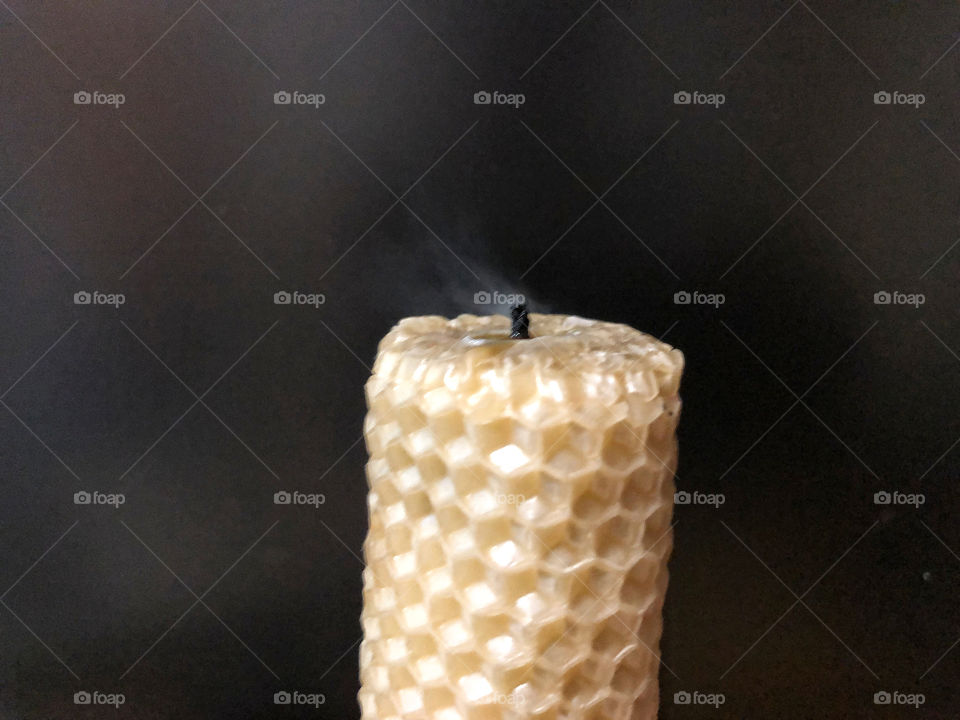 fading candle with honeycomb texture on black background