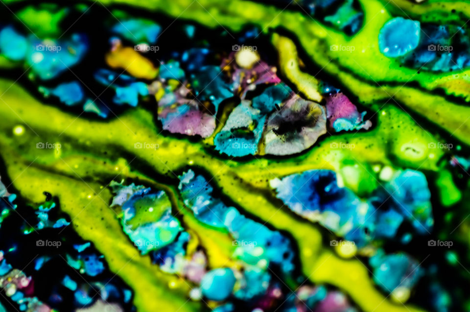 The ink to refill the printer cartridge was spilled onto the white washbasin and the paints blended into abstract drips and patterns