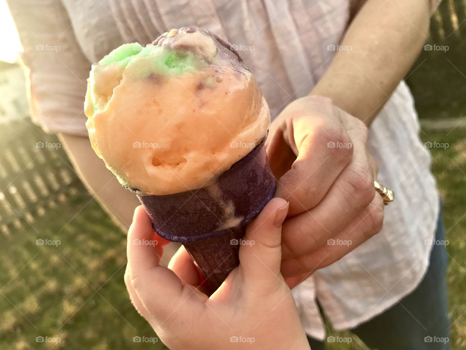 Parent handing child ice cream cone