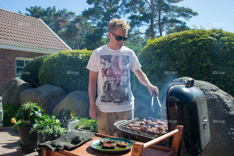 Man preparing food on barbecue grill