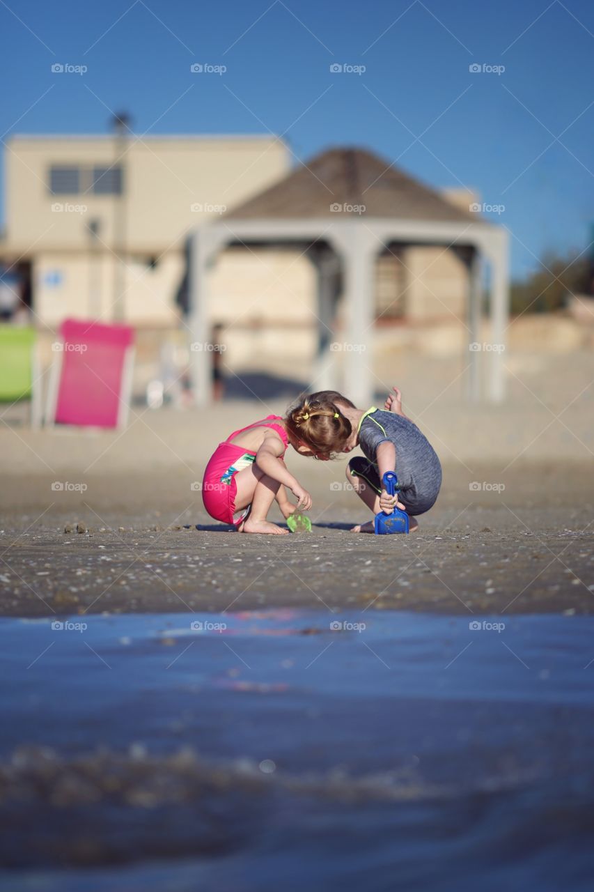 Girl and boy playing on the beach