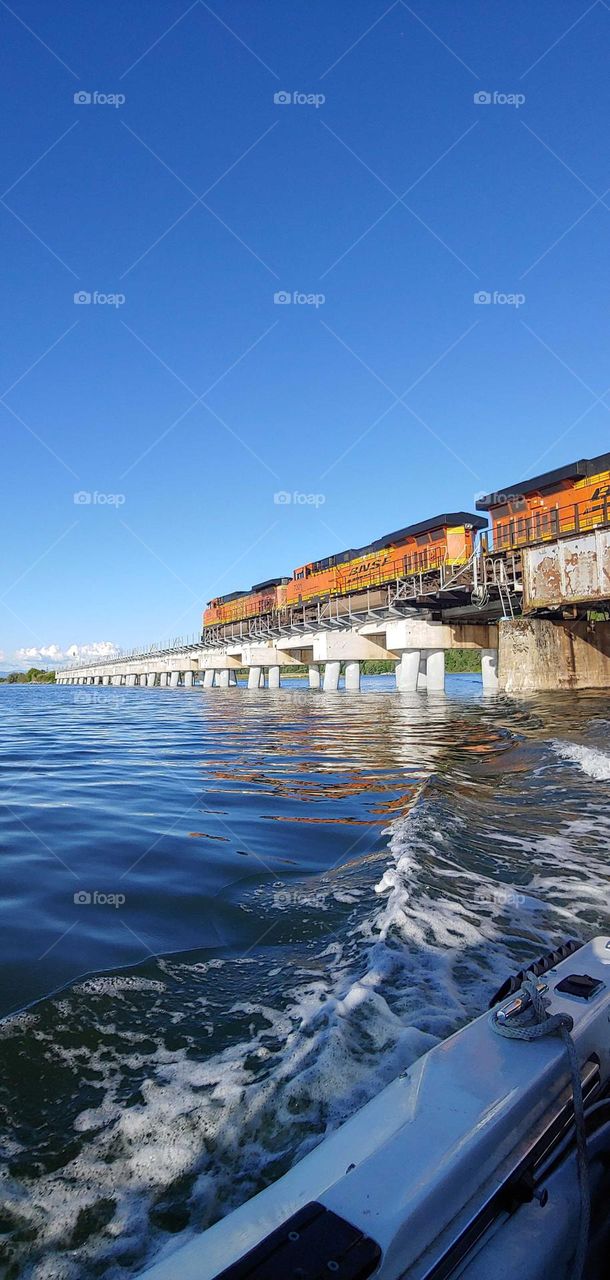 Cruising under the bridge as the train goes by .