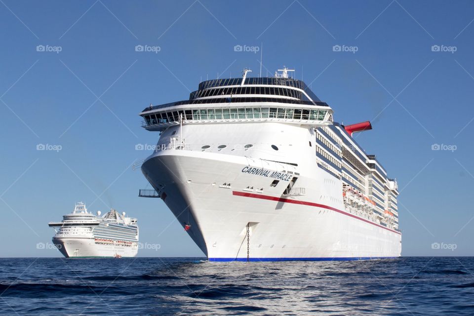 Front 3/4 angled view of a Carnival cruise ship on a bright, clear day