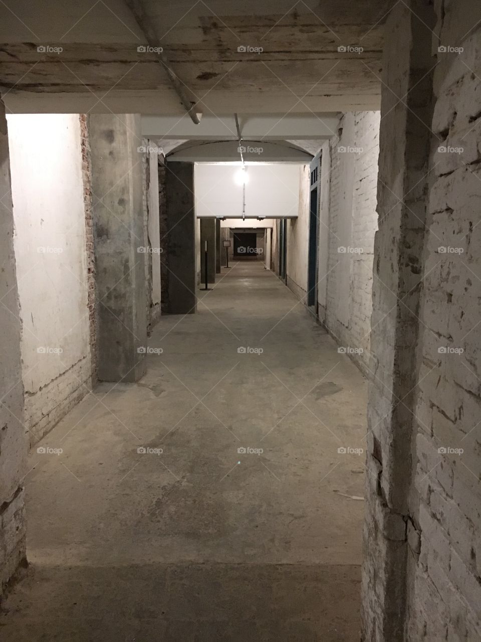 Old basement hall of a jail, walls crumbling, lights hanging, no color and creepy