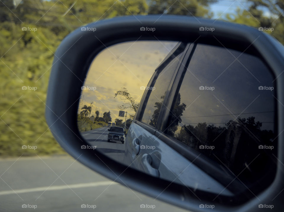 Skylar dusk seen on side mirror of a car