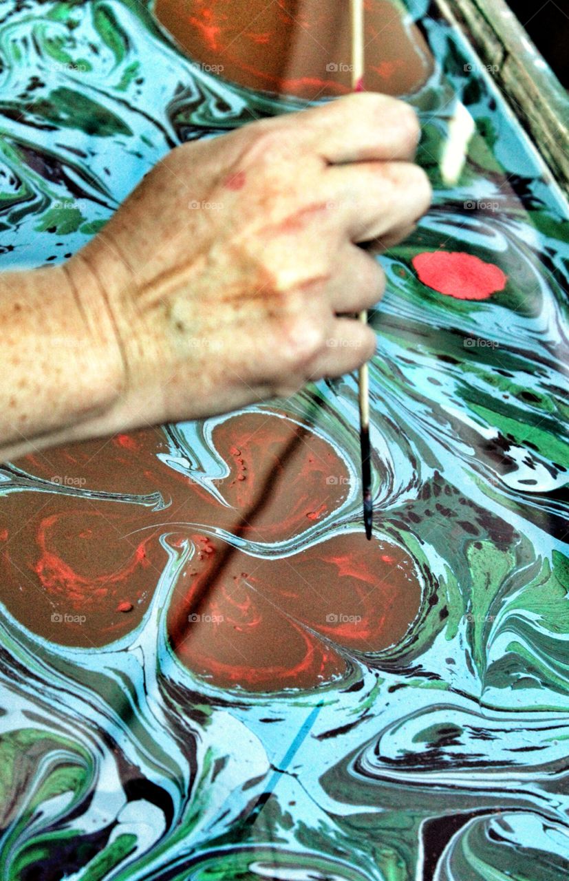 Silk screen. Artisan painting colors on a silk scarf