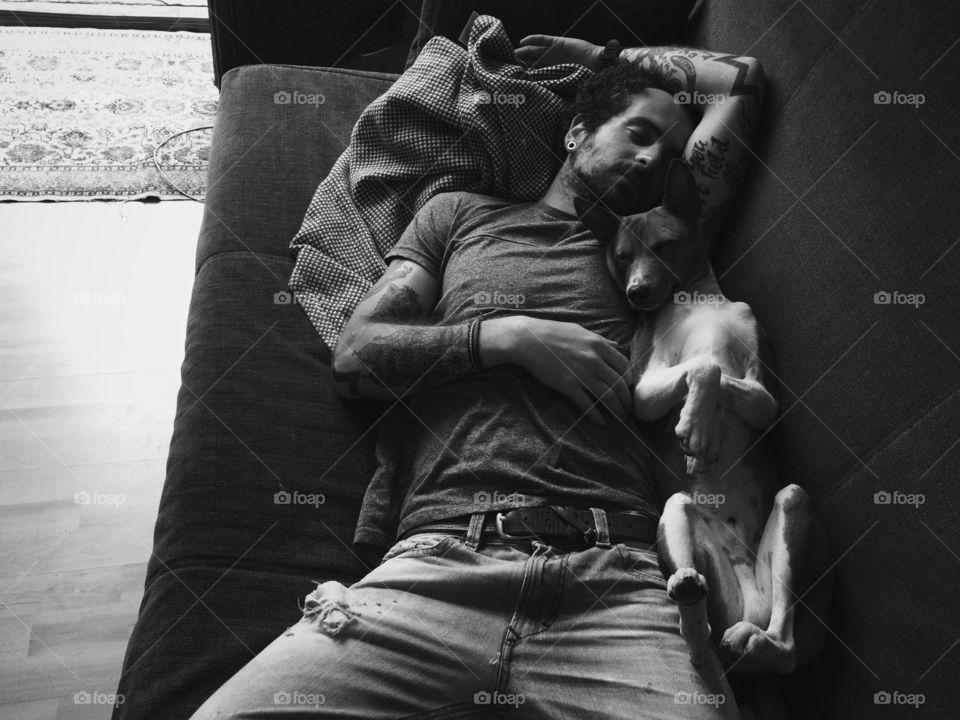 Tired man sleeping with dog
