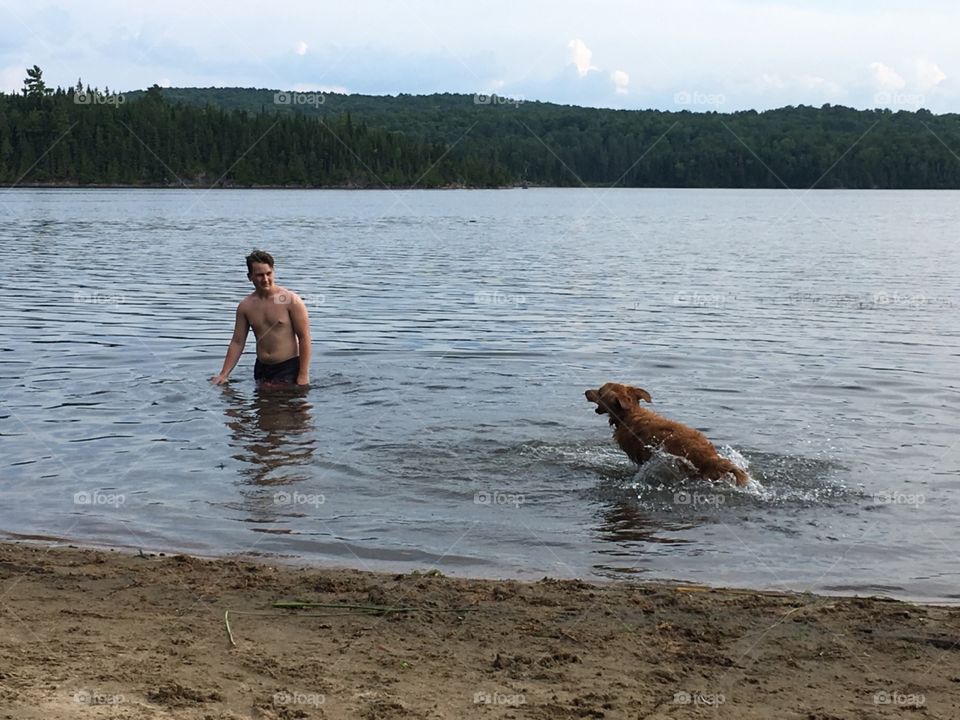 Swimming dog and boy