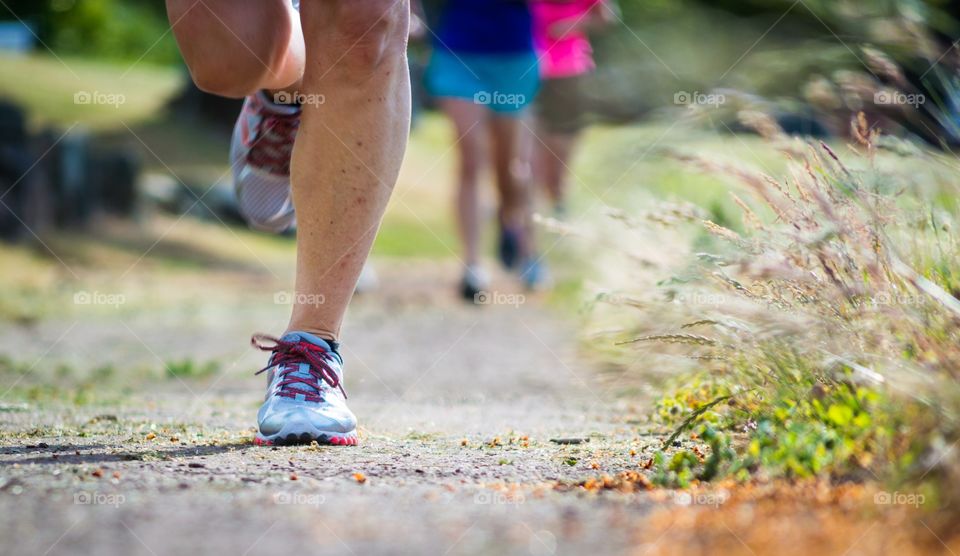 Afternoon run. Women running on the track on a sunny evening in the summer.