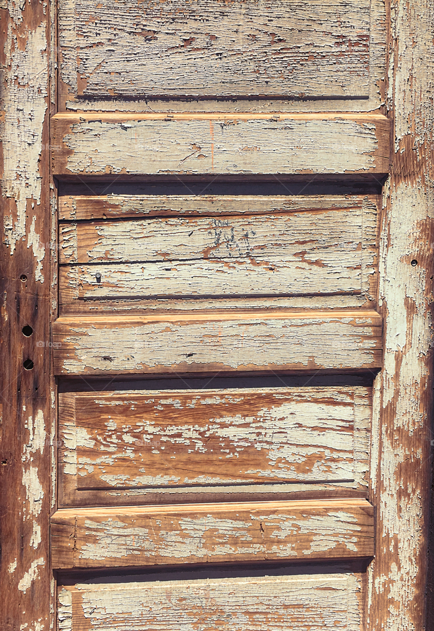 Old antique door with chipped white paint.