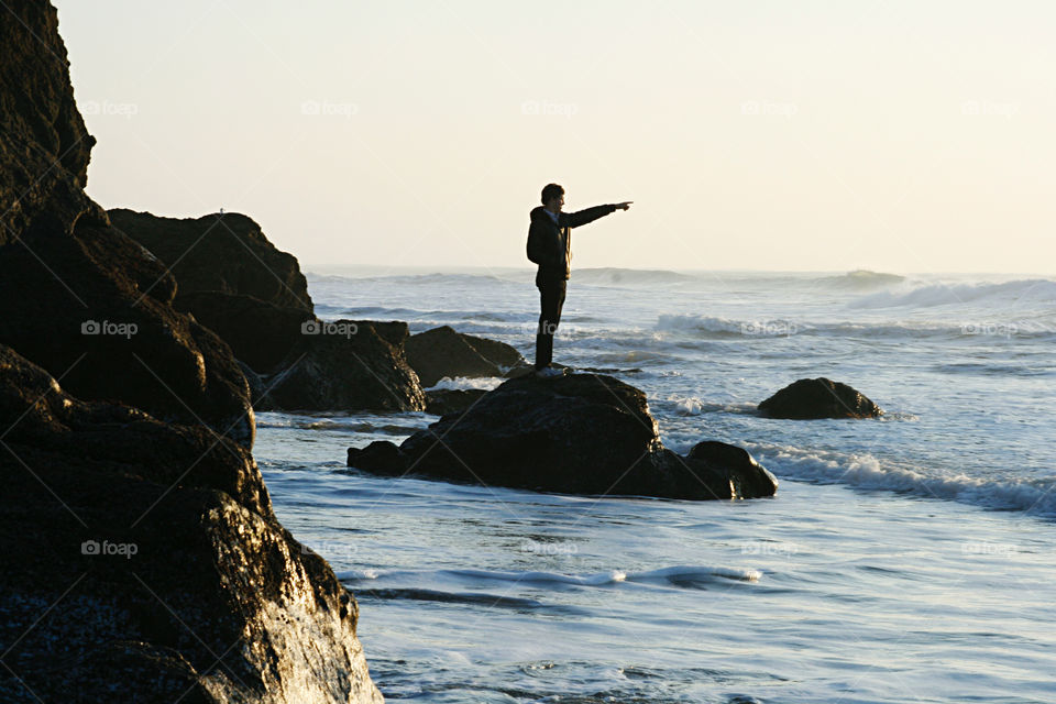 One person pointing to the ocean 