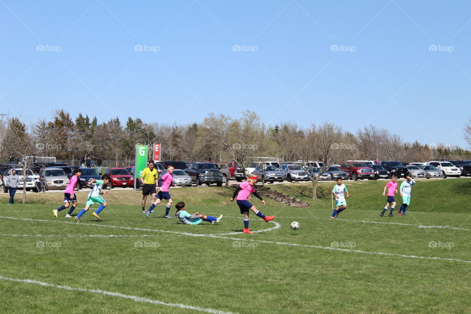 Kids playing soccer in a beautiful spring day 