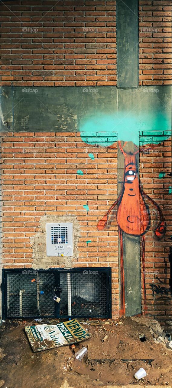 boneco com cabeça de arvore grafitado no centro da cidade.