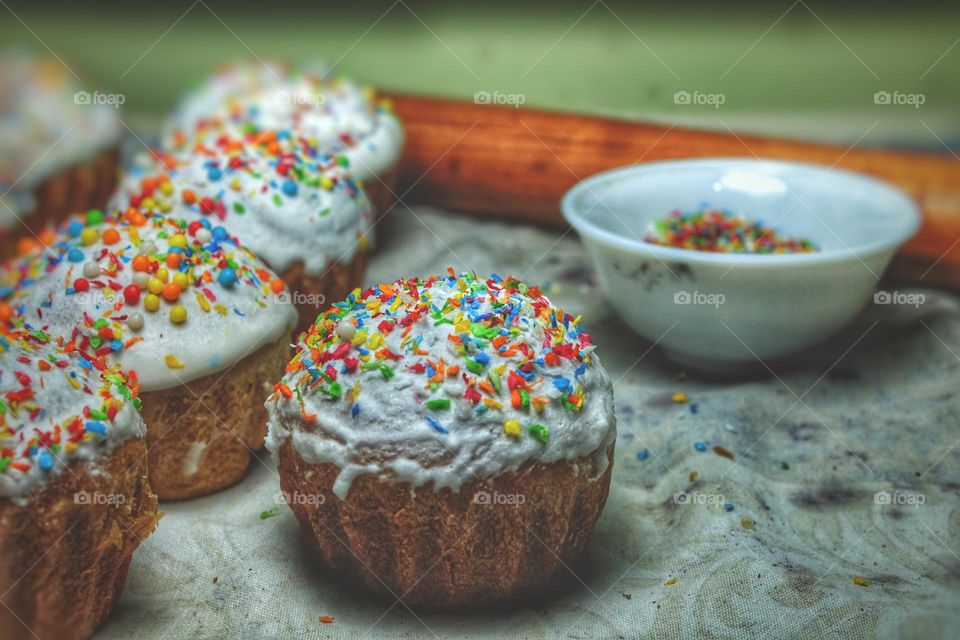 baking muffins for a holiday dinner. White icing on the cake is sprinkled with colored confectionery topping. Close photo on the theme of Easter and the resurrection of Jesus Christ.