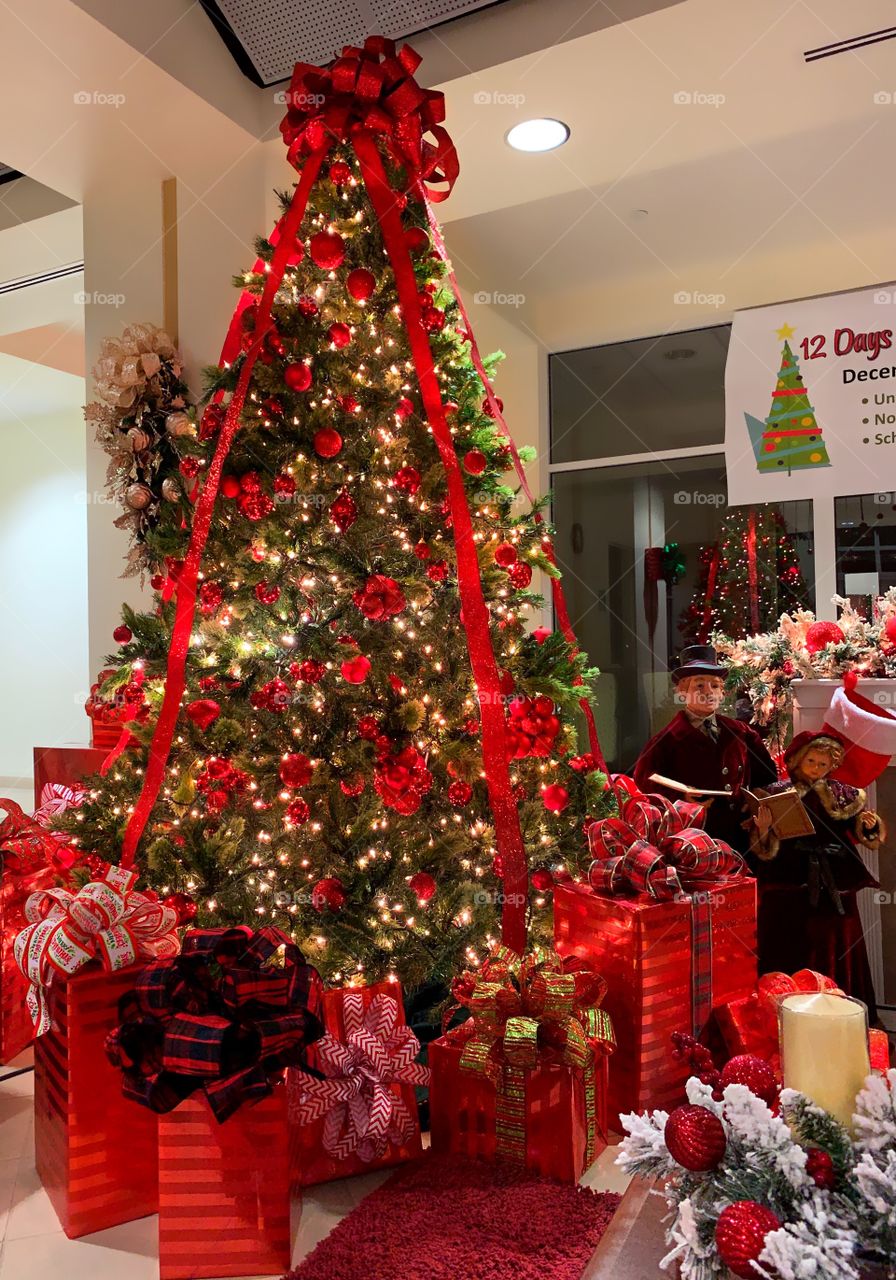 Beautiful warm and sparkling Christmas tree with lots of presents waiting to be opened.