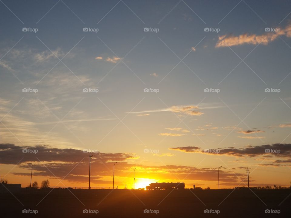 sunset near a highway, transport truck rolling into the night