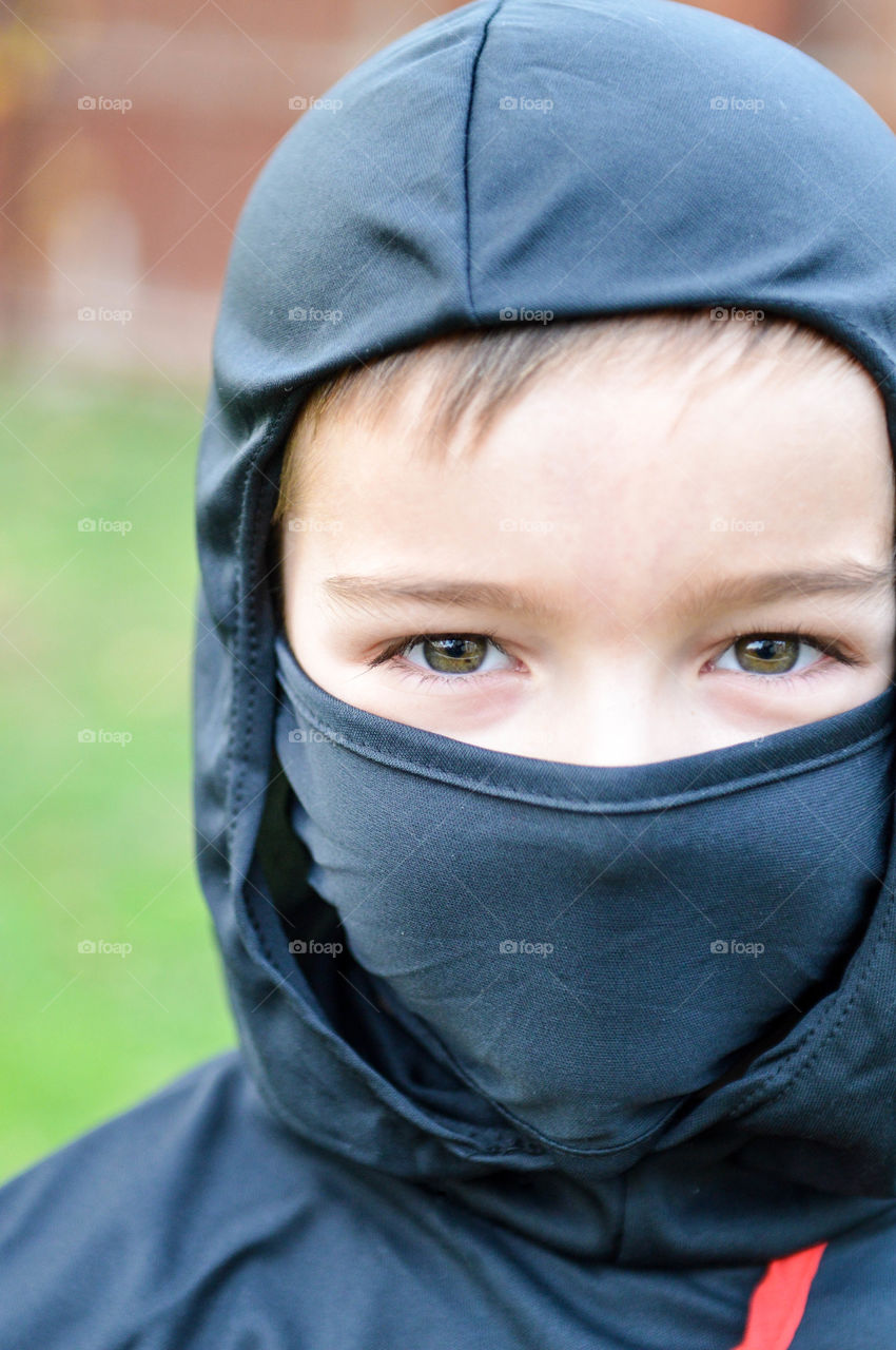Close-up of young boy's face wearing a mask with eyes exposed