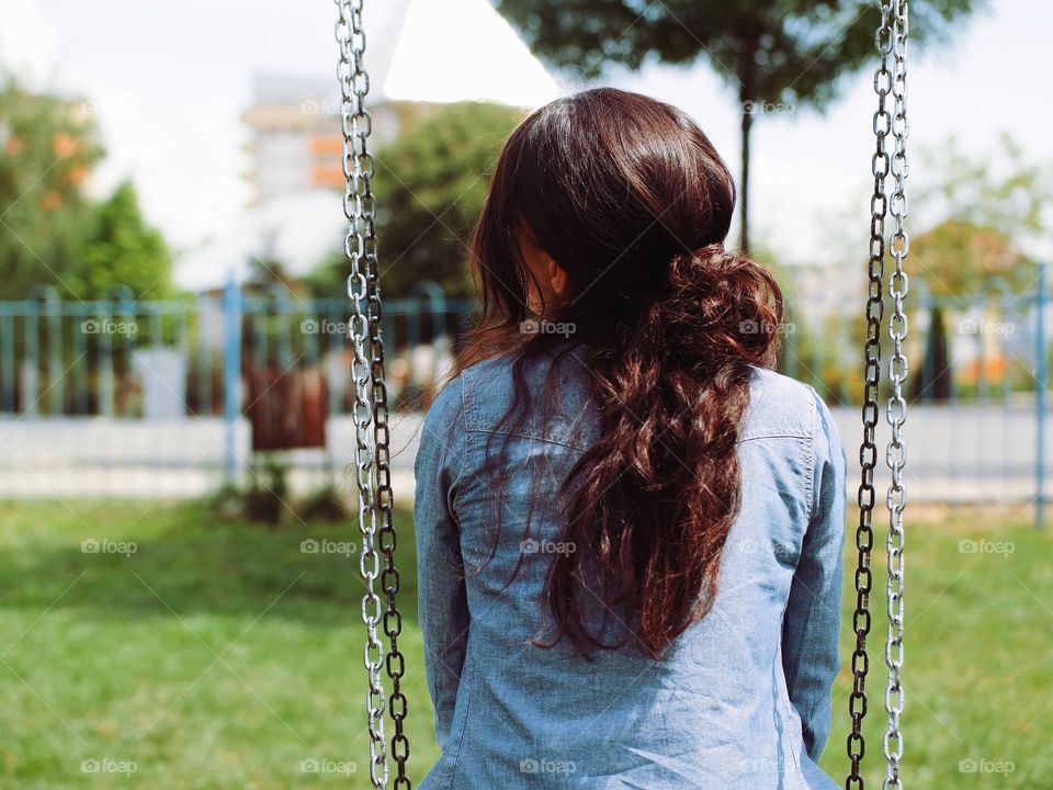 Rear view of a woman sitting on swing