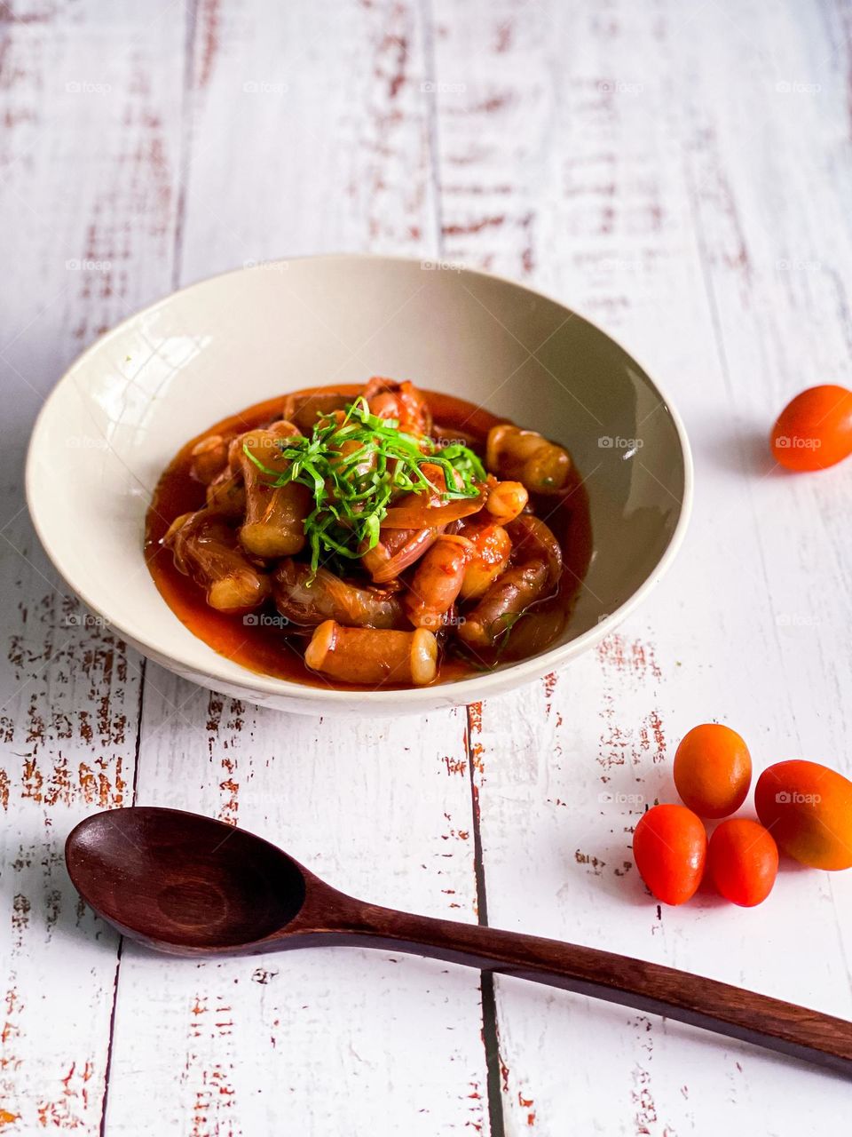 Spicy seafood dish on a white wooden table. Close up view