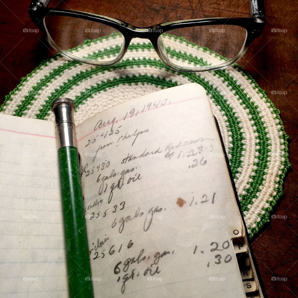 notebook, mechanical pencil and glasses on antique desk.