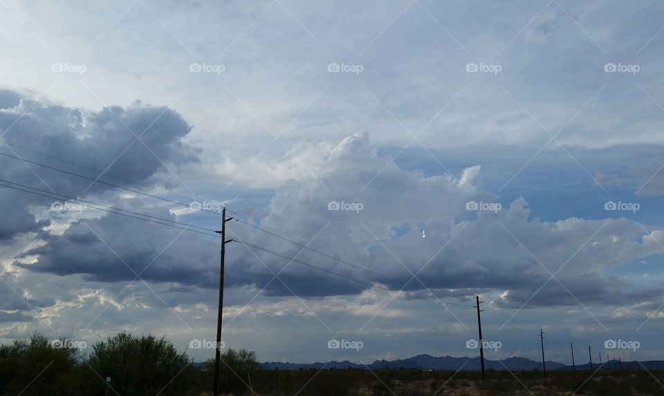Puffy clouds and power lines in the Sonoran desert of Arizona.