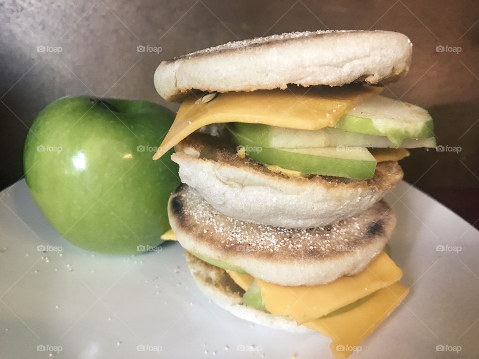 A stacked sandwich of sliced green apples and melted cheddar cheese inside English muffins. USA, America 
