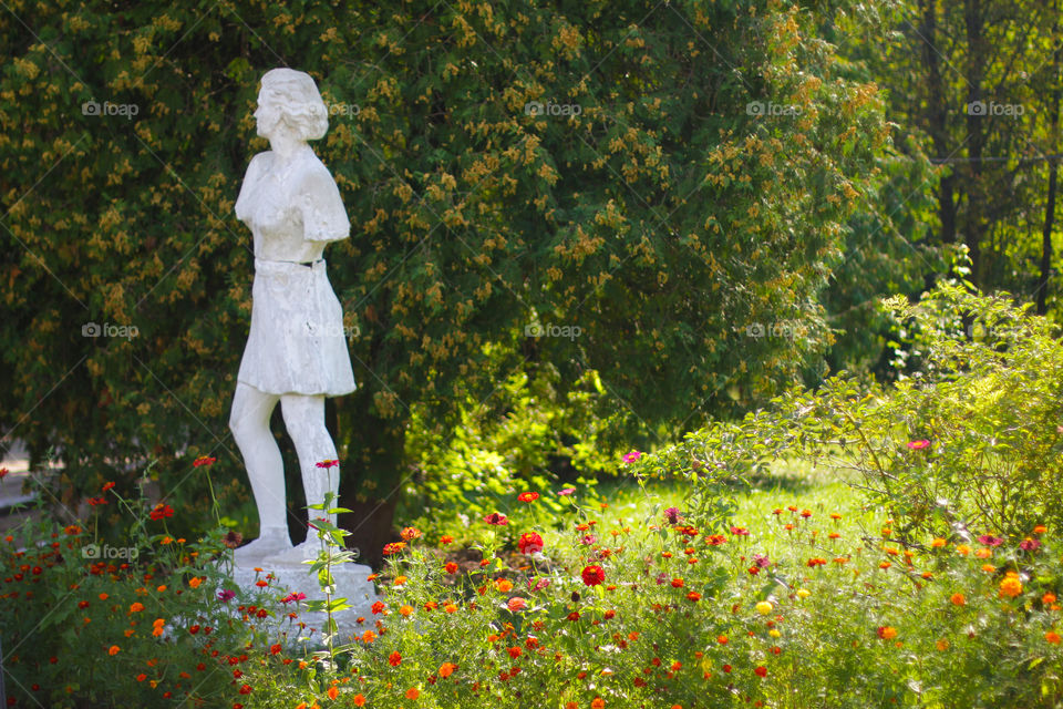 Sculpture woman in the park. Summer colors