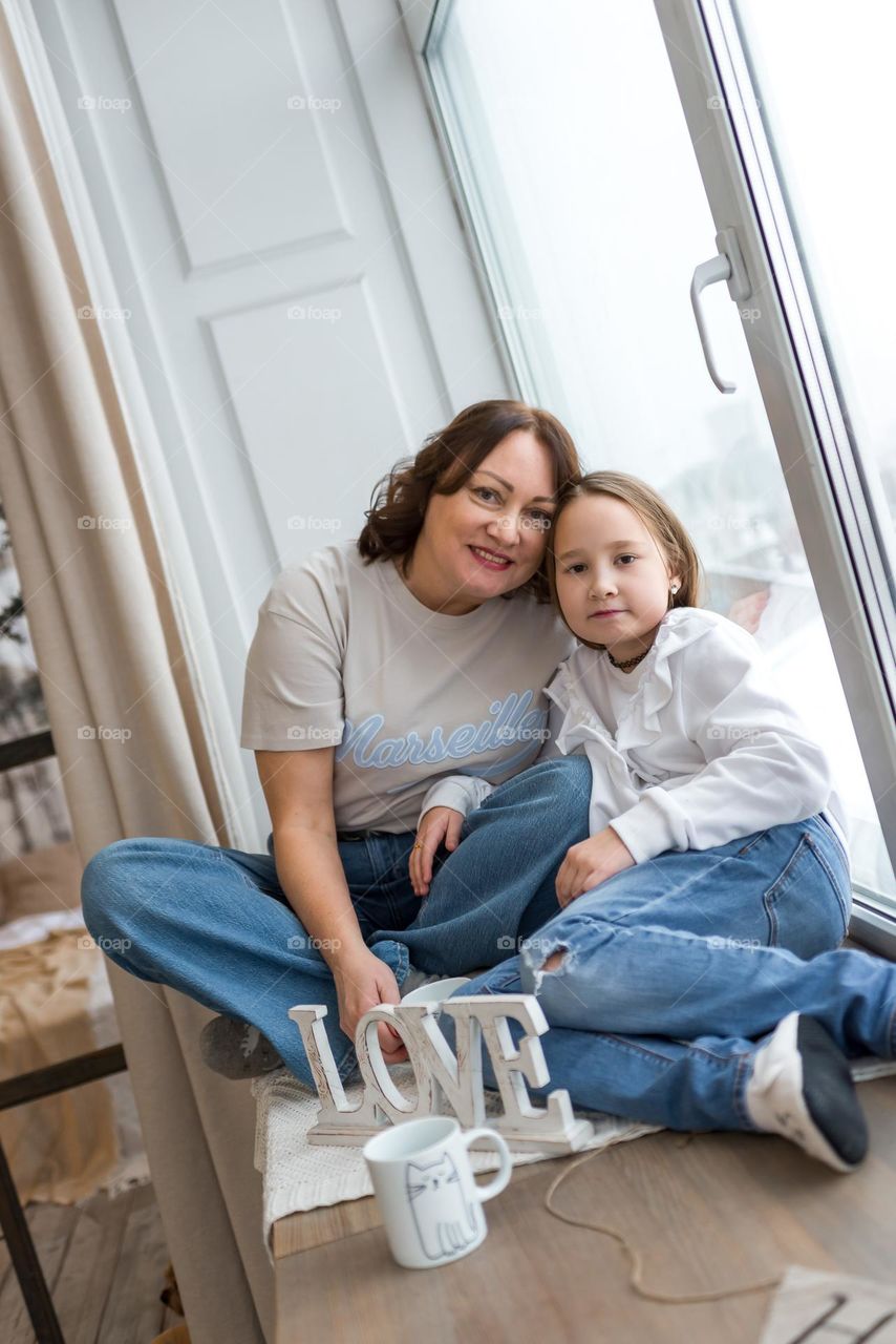 Mom and dough sitting on the windowsill 