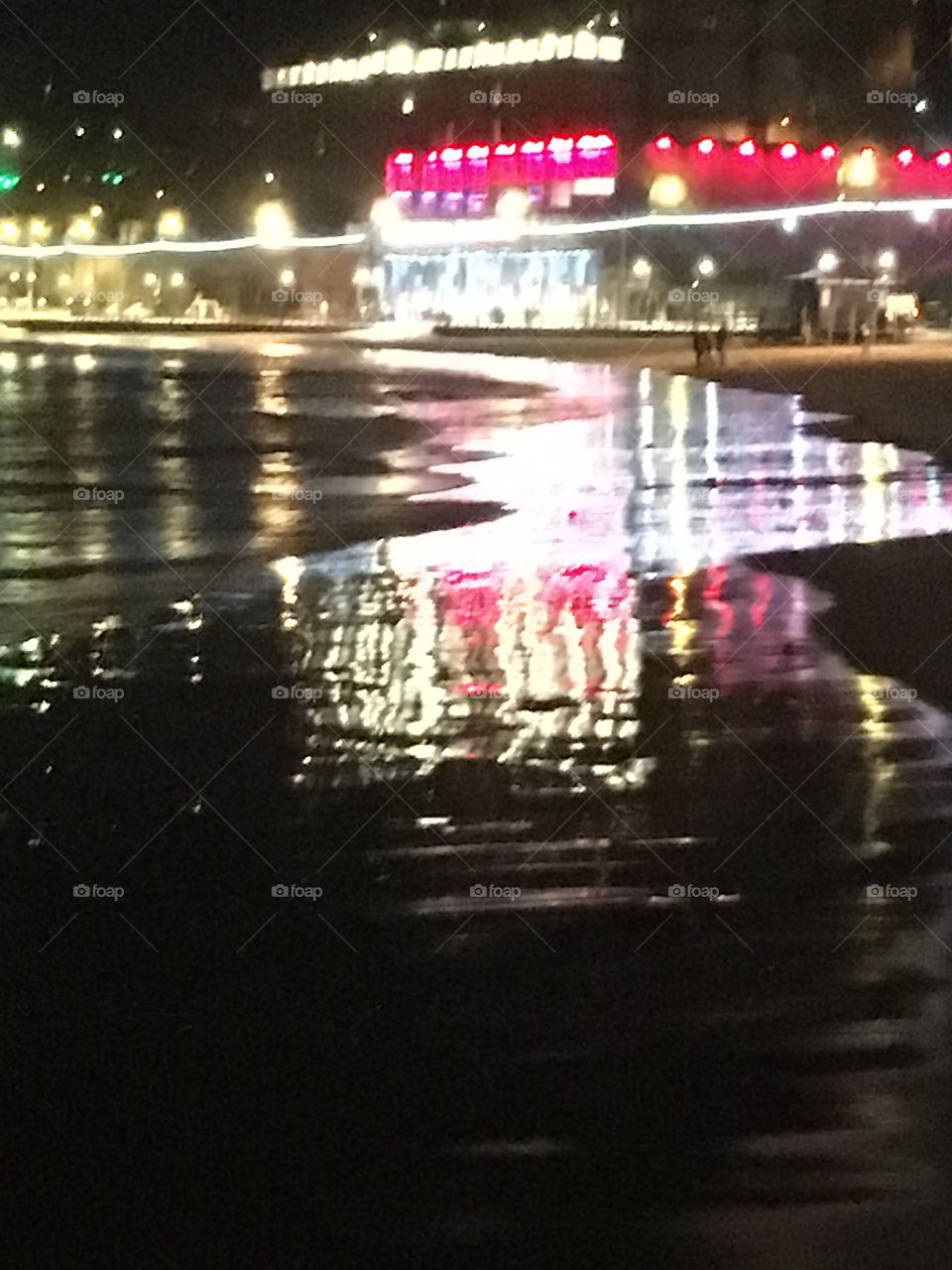 Seaside lights reflecting on the beach