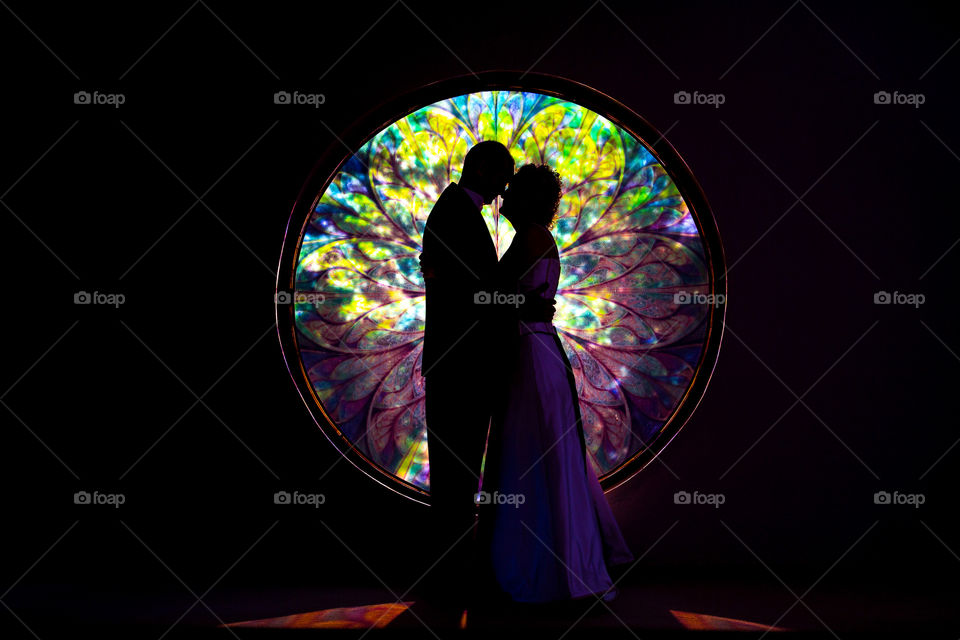 Window view - beautiful stained glass window with silhouette of a couple