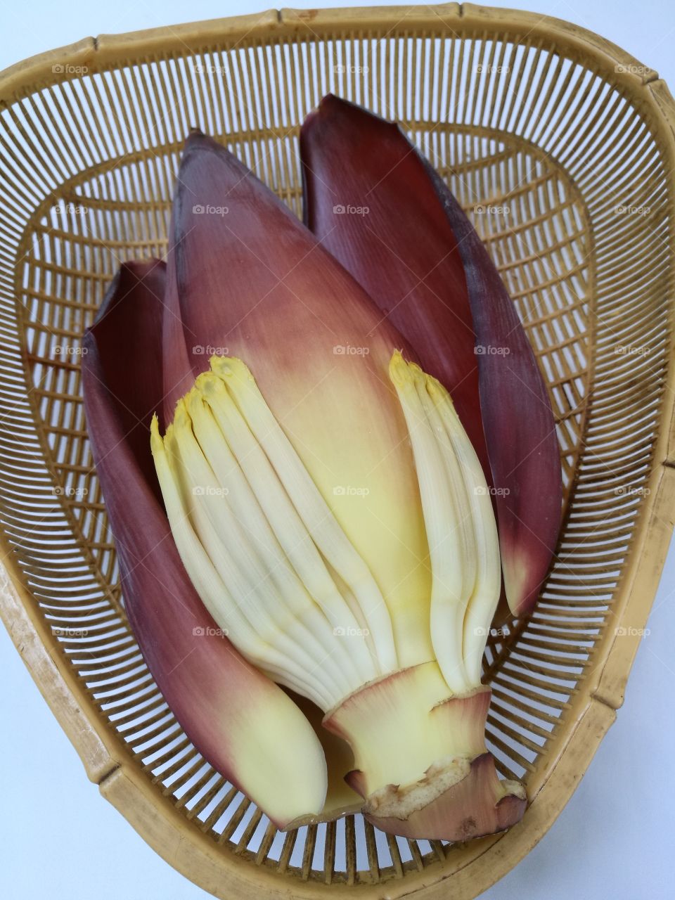 Banana blossom in a basket isolated on white background.