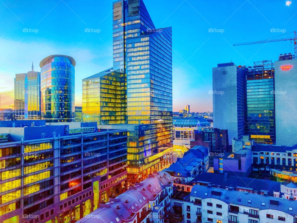 A full spectrum of colors during sunrise shown in the sky and the reflection of the sky in the glass of the business offices of the financial district of the city