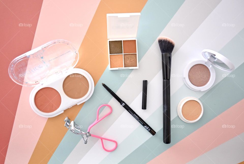 Makeup, flat lay, colorful cosmetics on linear, colorful background TopView