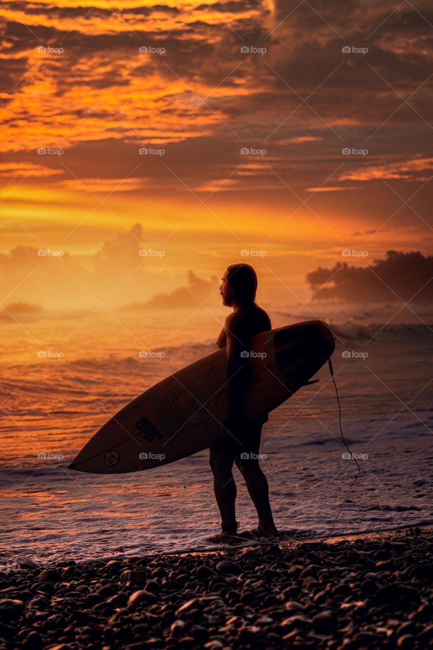 Surfer silhouette in magical sunset in Costa Rica