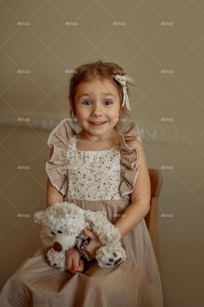 Vintage portrait of a beautiful little girl with teddy bear 