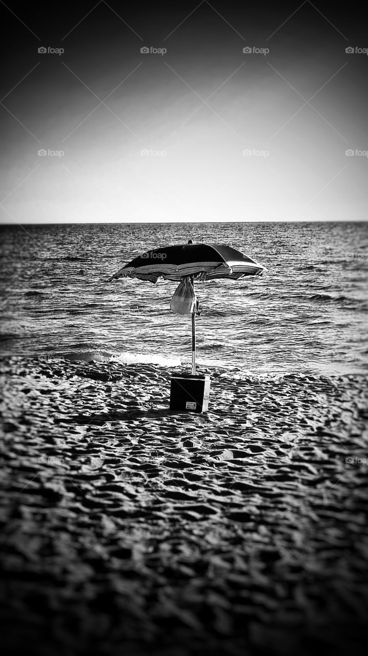 a fridge under an umbrella on the beach