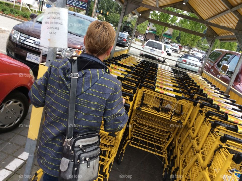 Yellow Mission Yellow Grocery Shopping Carts Trolleys. Woman returning yellow grocery shopping cart in parking lot